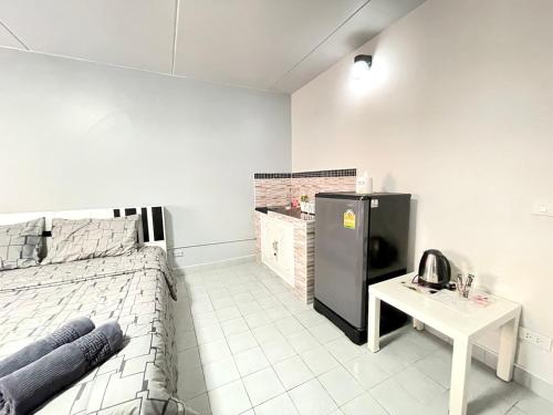 暖武里府Impact Arena C3 Milo的客房设有床、桌子和冰箱。