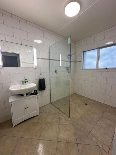 阿希帕拉Foreshore Mukies 2,0的一间带水槽和玻璃淋浴的浴室