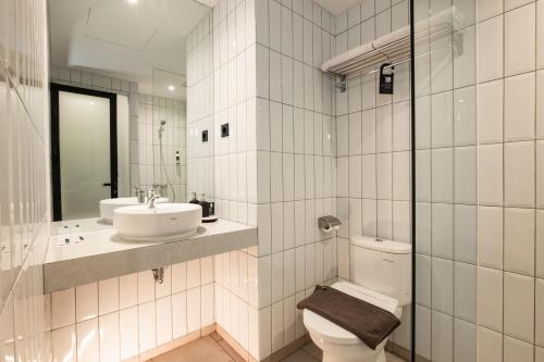 三宝垄Assa Hotel的白色的浴室设有卫生间和水槽。