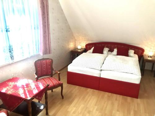 新策勒Room in Apartment - Haus Im Grunen House in the green的一间卧室配有红色的床和椅子