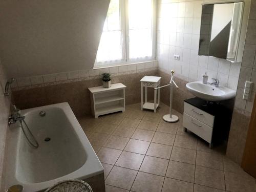 新策勒Room in Apartment - Haus Im Grunen House in the green的带浴缸和盥洗盆的浴室