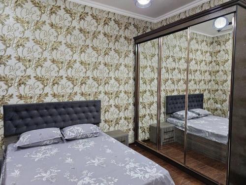 布哈拉Новая 3-х комнатная квартира Мечта的一间卧室配有一张床和镜子