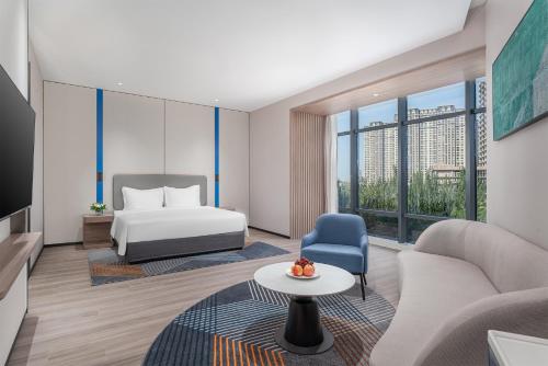 银川银川阅海智选假日酒店的酒店客房配有床、沙发和桌子。