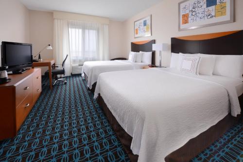 本殖民地Fairfield Inn & Suites by Marriott Dallas Plano The Colony的酒店客房设有两张床和电视。