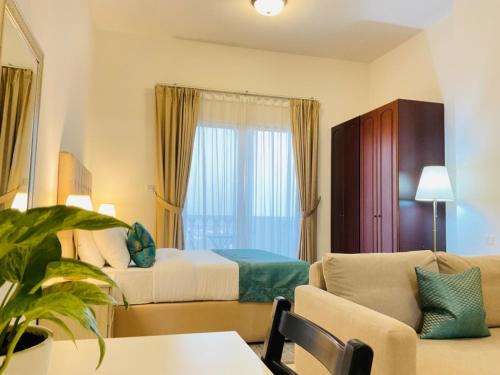 拉斯阿尔卡麦Hala Holiday Homes - Al Hamra Village, RAK的酒店客房,配有床和沙发