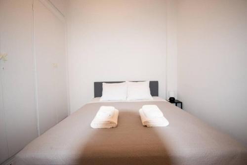 比雷埃夫斯Chic Kastella Apt by Mikrolimano的一间卧室配有一张床,上面有两条毛巾