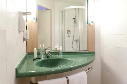 巴拉卡宜必思毕尔巴鄂巴拉卡尔多酒店的一间带绿色水槽和镜子的浴室