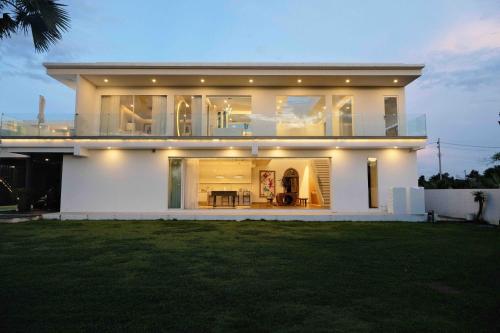 清迈Palm Villa - Award Winning Modern Luxury & Exclusive Villa Resort的大型白色房屋,设有大窗户