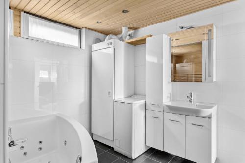 赫尔辛基Happy Home Lauttasaari的白色的浴室设有水槽、浴缸和镜子