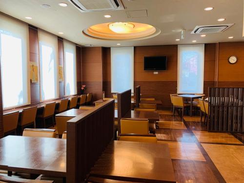 多贺城市Hotel Route-Inn Sendaiko Kita Inter的一间设有桌椅和电视的会议室