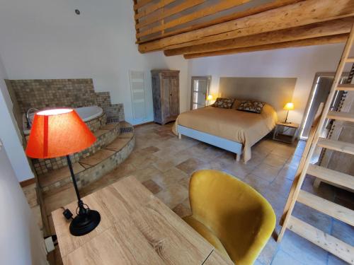 Boisset-et-GaujacGite au sein d'un Mas Provençal的一间卧室配有一张床、一盏灯和一把椅子