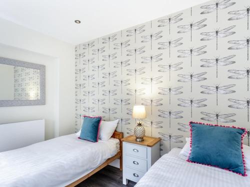 索海姆The Orange Tree Thornham的一间卧室设有两张床,墙上贴有蒲公英。