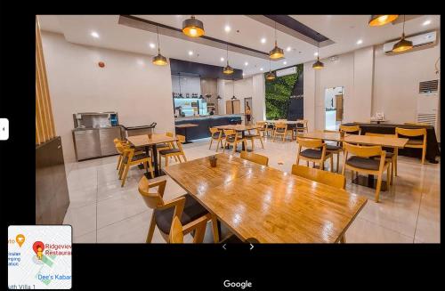 Ma. Awani Hotel & Suites的一间空餐厅,配有木桌和椅子