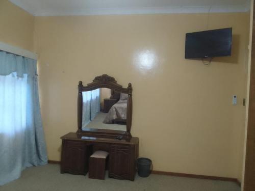PrieskaHolope Self-Catering Accomm的卧室配有一面镜子的墙壁