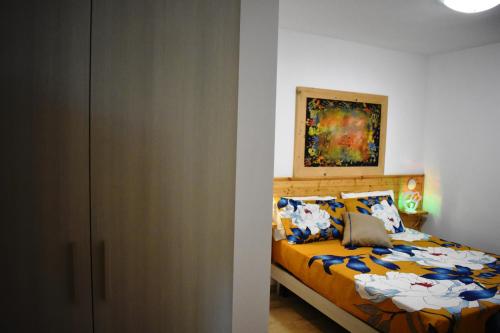 比谢列Art Village Residence的卧室配有一张床,墙上挂有绘画作品