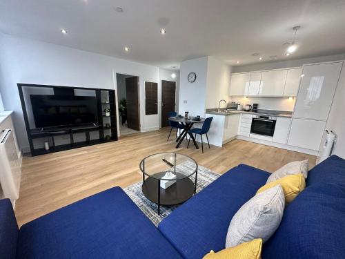 曼彻斯特1 Bed Apartment near Old Trafford with free car park的一间带蓝色沙发的客厅和一间厨房
