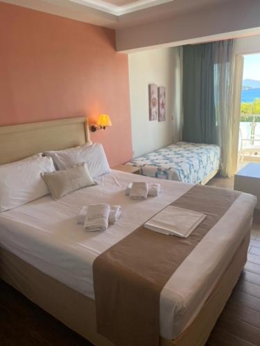 奈德里Armeno beach hotel的卧室配有一张大白色床和窗户