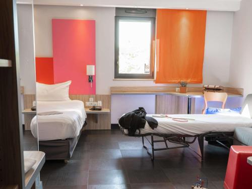 阿利仙罗马斯-瓦伦斯TGV车站宜必思尚品酒店的一间设有两张床和一张桌子及椅子的房间