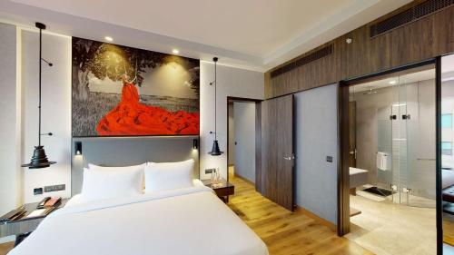 钱德加尔Radisson RED Chandigarh Mohali的一间带白色大床的卧室和一间浴室