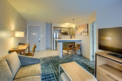 南本德Homewood Suites by Hilton South Bend Notre Dame Area的带沙发和桌子的客厅以及厨房。