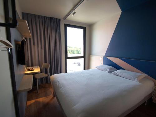 卢代阿克ibis budget Loudéac Vélodrome的卧室配有白色的床和蓝色的墙壁
