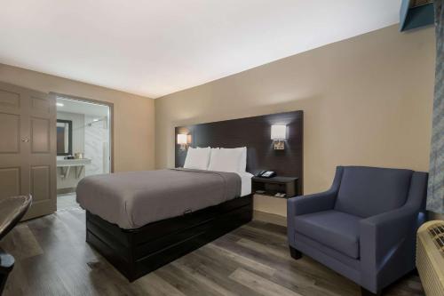 奥兰多Quality Inn & Suites Altamonte Springs Orlando-North的一间卧室配有一张床和一张蓝色椅子