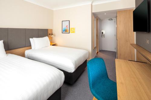 海维康Holiday Inn High Wycombe M40, Jct.4, an IHG Hotel的酒店客房,设有两张床和一张蓝色椅子