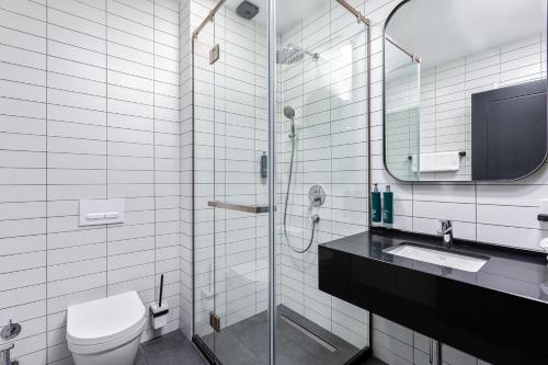 第比利斯Gratus Aparthotel Tbilisi的浴室配有卫生间、盥洗盆和淋浴。