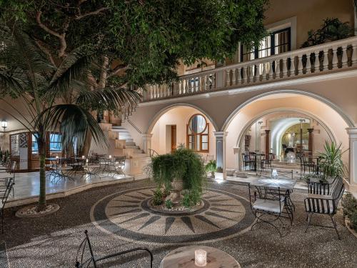 干尼亚卡萨德尔斐诺温泉酒店的大堂设有棕榈树和桌椅