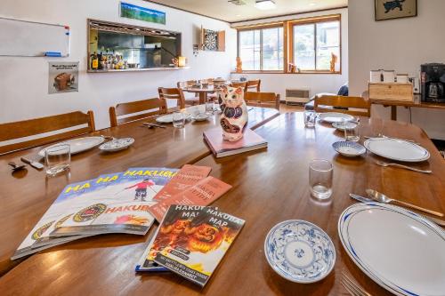 白马村Iimori Vista的餐桌上摆放着书籍和盘子