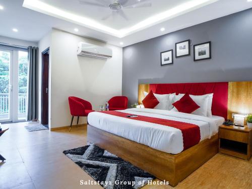 古尔冈Saltstayz Hotel Huda City Centre的一间卧室配有一张大床和红色床头板