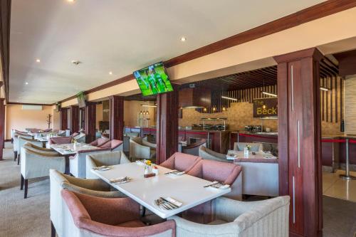 NyangaTroutbeck Resort的一间带桌椅的餐厅和一间酒吧