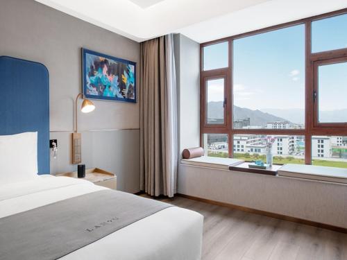 拉萨拉萨市政府西藏大学兰欧国际酒店的酒店客房设有一张床和一个大窗户