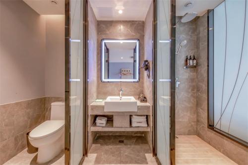 Shizuishan尚客优悦鄂尔多斯棋盘井镇政务服务中心酒店的一间带水槽、卫生间和镜子的浴室