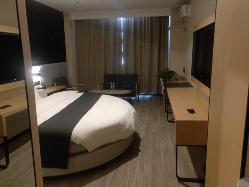 喀什尚客优品喀什疏勒四十一团草湖镇酒店的酒店客房设有一张大床和一张书桌。