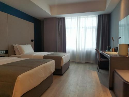 日喀则日喀则龙江路兰欧酒店的酒店客房配有两张床和一张书桌