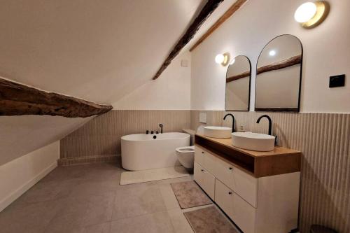 Les Jardins de Rosie的浴室配有两个盥洗盆和浴缸。