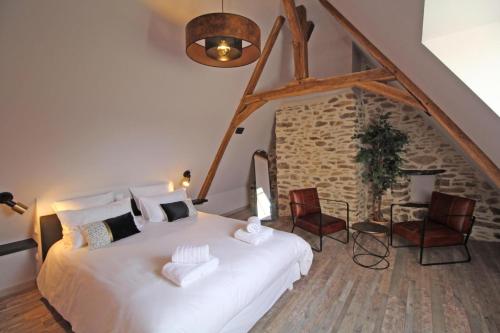 MeuzacGite des crouzas的卧室配有一张白色大床和两把椅子