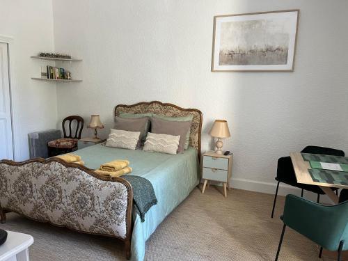 格里尼昂Au Petit Faubourg的卧室配有1张床、1张桌子和1把椅子