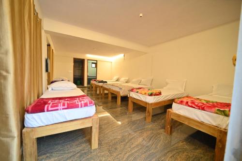 库斯哈尔纳加尔Coorg HomeStay Resort的一间客房内的四张床