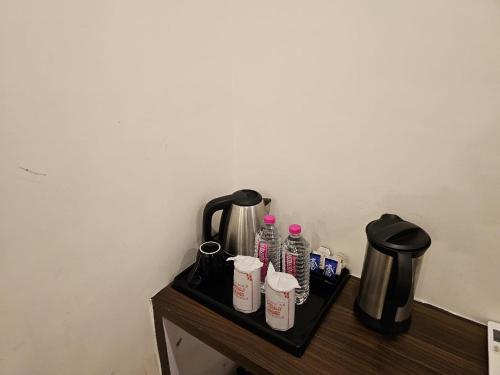 勒克瑙HOTEL ORCHID的配有瓶装水和咖啡壶的桌子