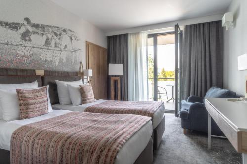 扎科帕内Hotel Aquarion Family & Friends - Destigo Hotels的酒店客房设有两张床和一个阳台。
