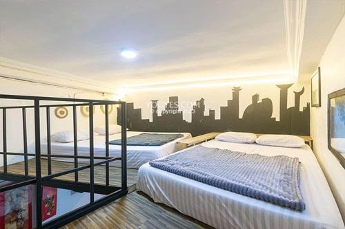 日惹Destiny House的墙上挂有城市壁画的客房内的两张床