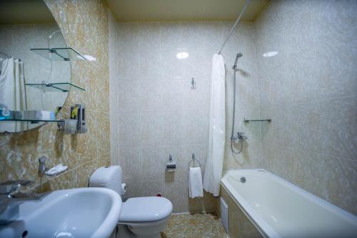 布哈拉Reikartz Modarixon Bukhara的浴室配有卫生间、盥洗盆和浴缸。