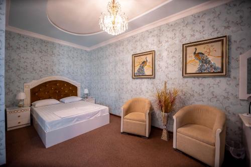 布哈拉Reikartz Modarixon Bukhara的一间卧室配有一张床、两把椅子和一个吊灯