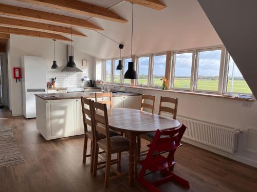 SkibbyNordgården - ferie på landet的厨房配有木桌和椅子