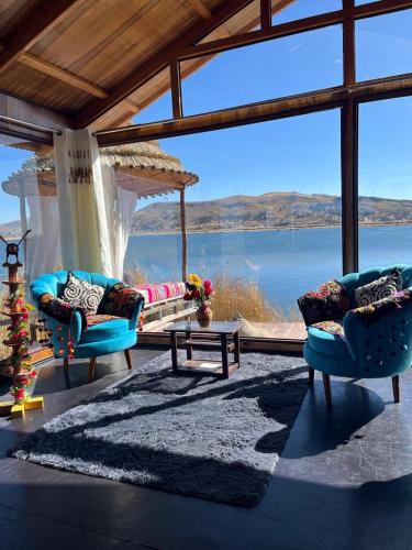 普诺Uros Walysuma Titicaca Lodge的一间带两把椅子的客厅,享有水景