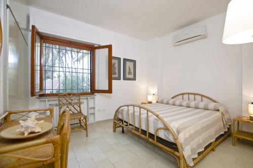 蓬塔阿拉Villetta Il Pino的一间卧室配有一张床、一张桌子和一个窗户。