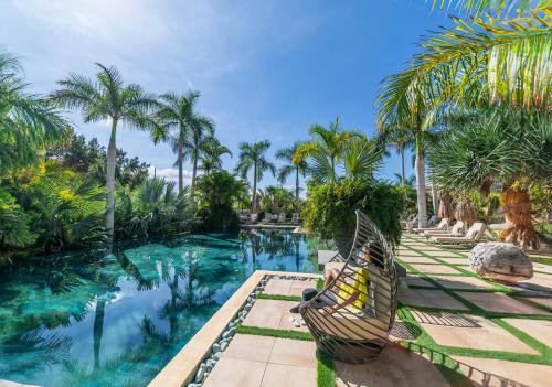 阿德耶Royal River, Luxury Hotel - Adults Only的棕榈树游泳池旁的吊床