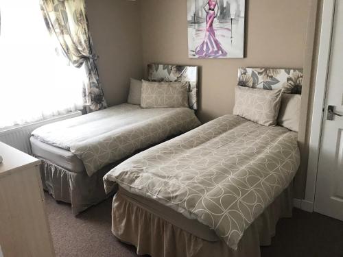 斯代普斯2 Bedroom Self-Catering Chalet的一间卧室设有两张床和窗户。